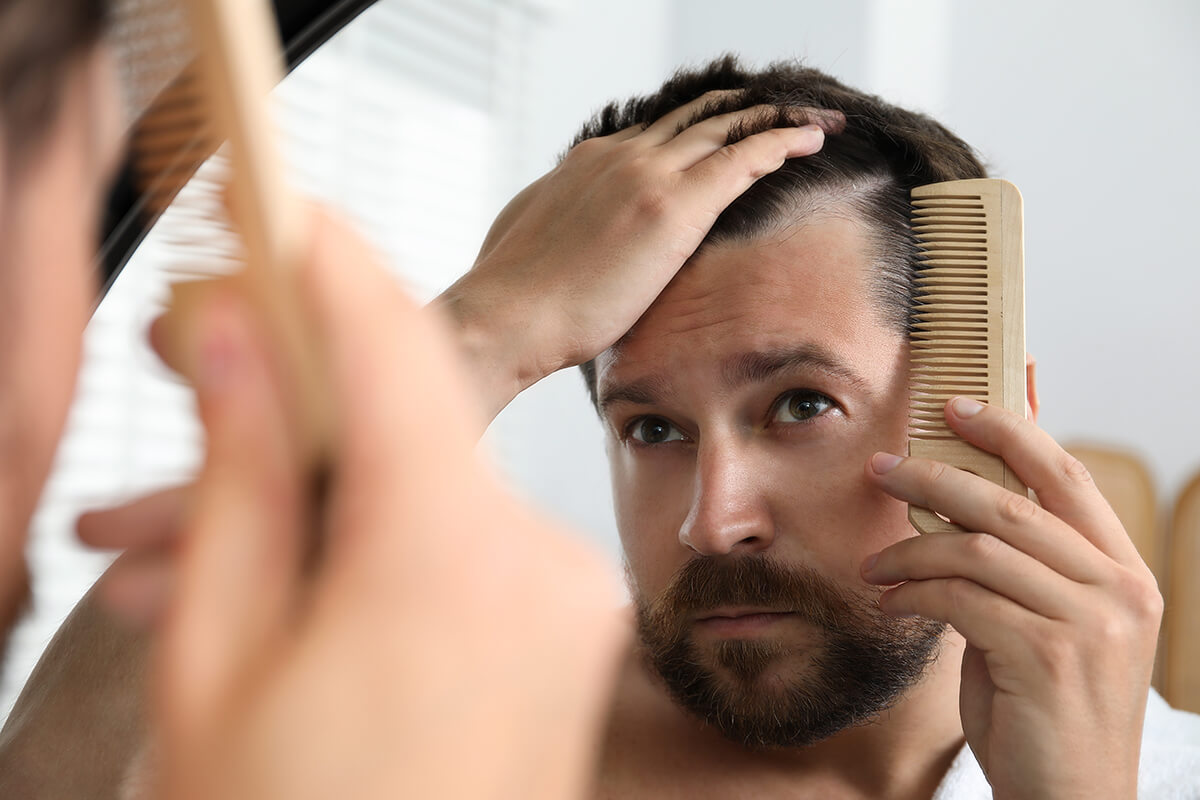 man-brushing-his-hair-near-mirror-indoors-alopeci-2025-05-26-19-52-22-utc (1)